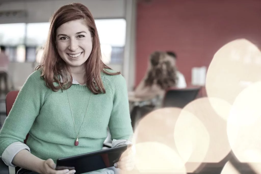 Confident female designer working on a digital tablet in red